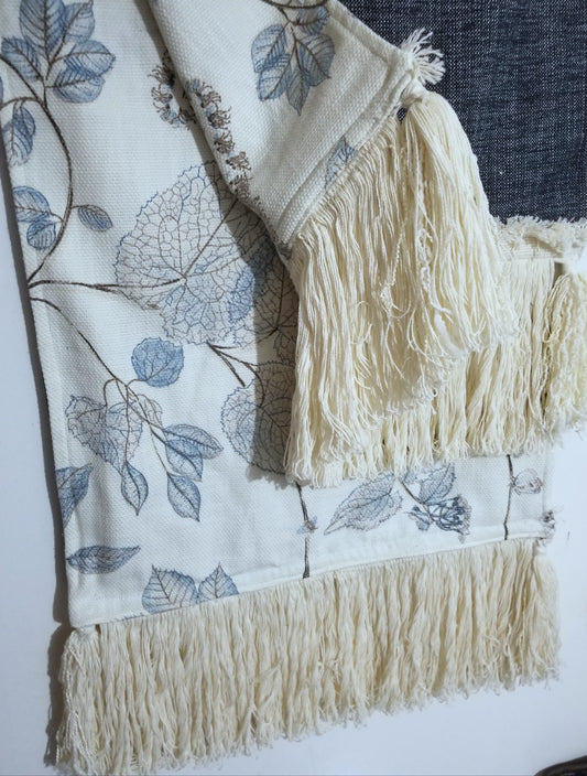 Bring effortless style to your home with this handmade limited edition luxury throw/runner. Woven in an intricate pattern of beige, black and blue, this 18x70 in piece is made from P Kaufmann Arboretum Fabric, with a woven reverse and tasseled edge. A truly unique piece for the boho decor enthusiast.